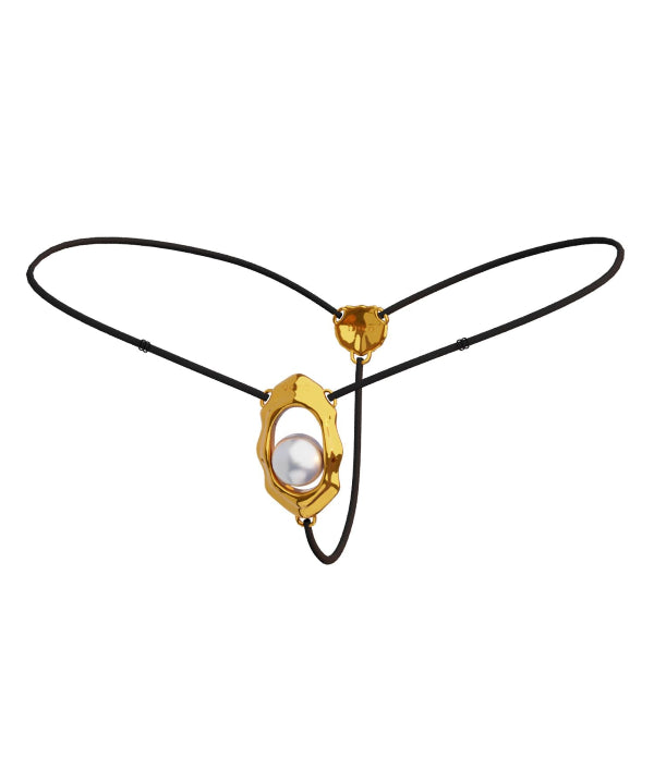 A gold-colored clitoral stimulator with a curved design and a rolling bead, attached to an adjustable black strap with a buckle.